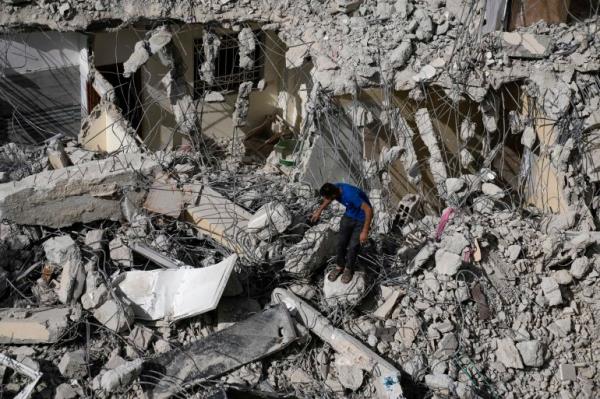 A Palestinian man inspects the damage to a building after Israeli forces raided the West Bank city of Jenin