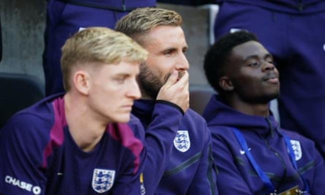 Luke Shaw (centre) watches on from the sidelines