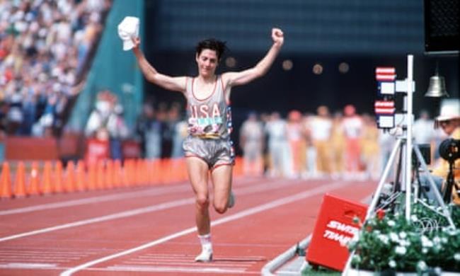 Joan Benoit approaches the finish line with her arms aloft in celebration