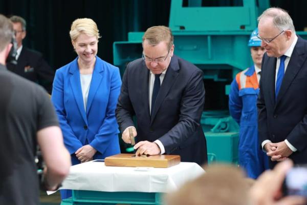 German Defence Minister Pistorius nailing coin to a board, part of the keel laying ceremony for a new frigate.