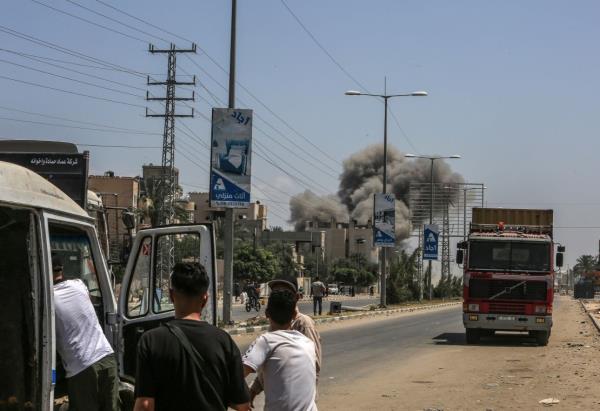 Palestinians watch smoke rising from a residential area following Israeli attacks on Deir al-Balah, Gaza, on June 8, 2024.