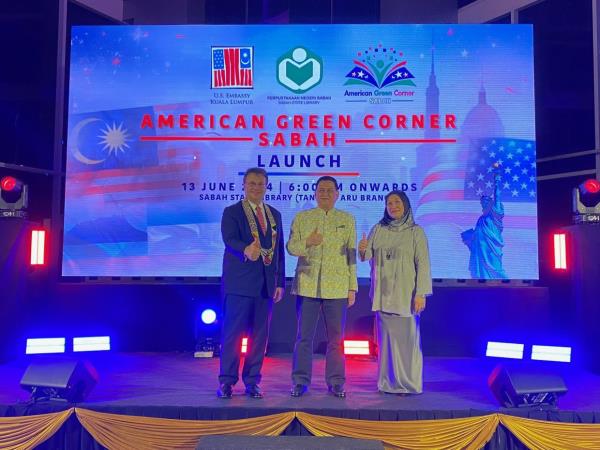 Arifin (middle), Kagan and Sabah State Library director Fatimah Abdillah giving the thumbs up to the launch of the American Green Corner.