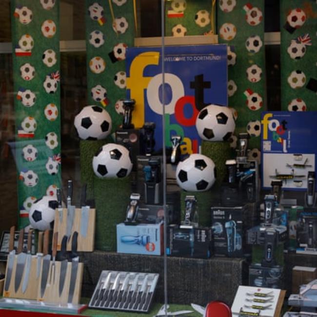A shop window in Dortmund display showing footballs next to knives and razors.