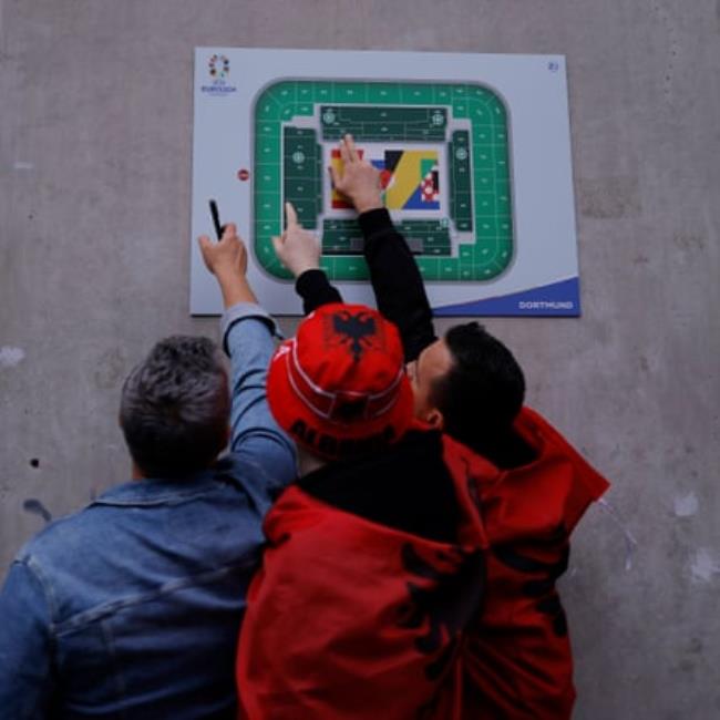 Albanian fans try to work out wher<em></em>e their seats are on a map in the ground before the group game between Italy and Albania.