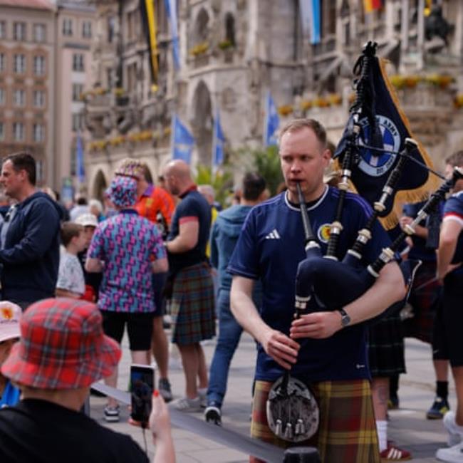 A piper plays for Scottish fans packed into Marienplatz outside the town hall in the centre of Munich.