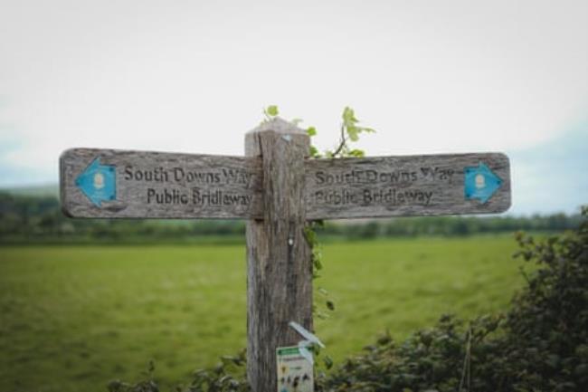 A wooden signpost points to the bridleway on the South Downs Way.