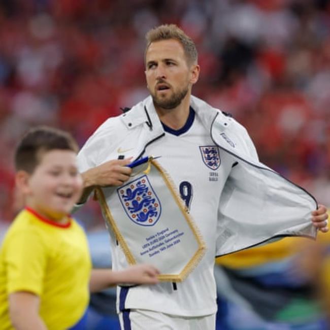England captain Harry Kane takes off his anthem jacket as excited mascots run off just before kick off during the 2024 European Champio<em></em>nship group game between England and Serbia.