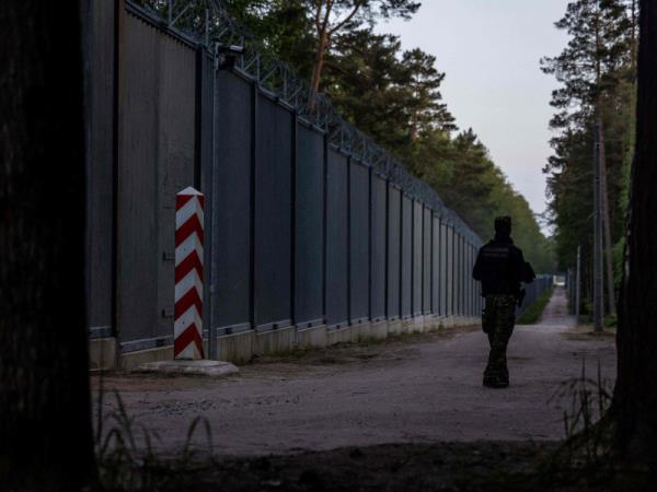 A border guard on patrol at the border wall between Poland and Belarus outside Bialowieza, Poland, on 29 May 2023.