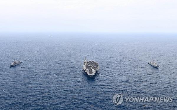 This file photo, provided by the Navy on April 12, 2024, shows South Korea's ROKS Seoae Ryu Seong-ryong destroyer (R), the USS Theodore Roosevelt aircraft carrier (C) and Japan's JS Ariake destroyer staging trilateral drills in internatio<em></em>nal waters south of the southern island of Jeju, the previous day. (PHOTO NOT FOR SALE) (Yonhap)