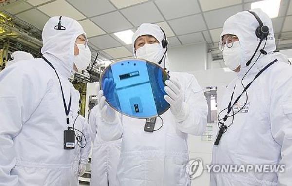 This file photo, provided by the industry ministry, shows Industry Minister Ahn Duk-geun (C) inspecting a semico<em></em>nductor production line during a visit to a SK hynix plant in Icheon, 56 kilometers southeast of Seoul, on Jan. 11, 2024. (PHOTO NOT FOR SALE) (Yonhap)