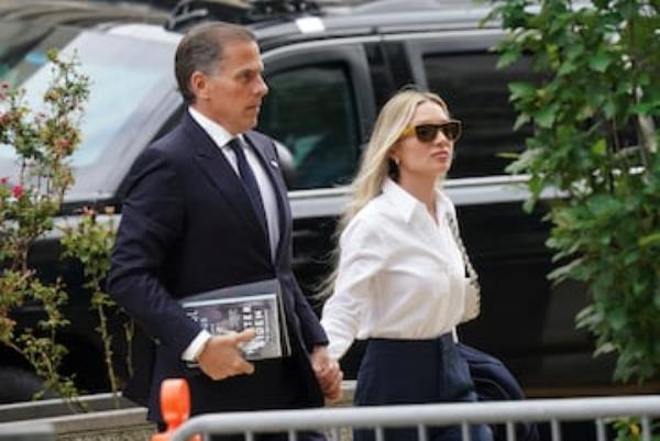 Carrying a copy of his memoir, Hunter Biden, son of U.S. President Joe Biden, and his wife Melissa Cohen Biden, arrive at the federal court in Wilmington, Delaware.