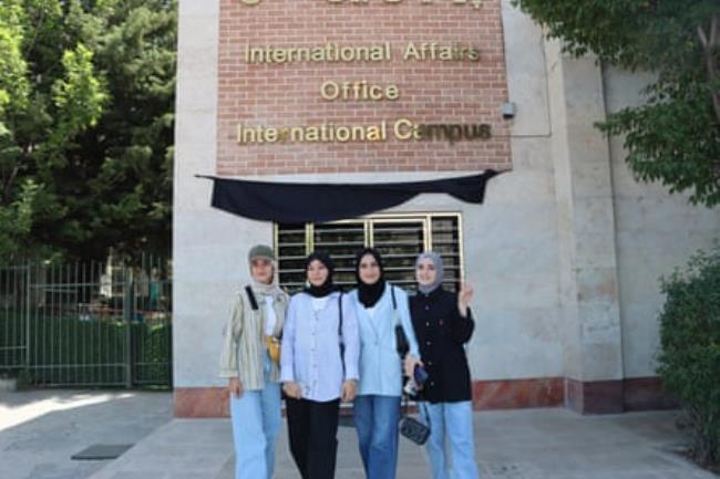 Hasina poses for a photo with three other girls in hijab outside the Iran University of Medical Sciences in Tehran