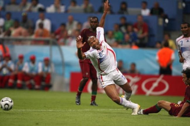 Thierry Henry (centre) falls as Ricardo Carvalho (right) sits on the pitch in the penalty area 