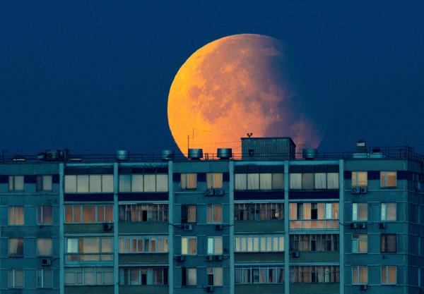 Partial lunar eclipse is seen over the residential building in Moscow, Russia, September 18, 2024.