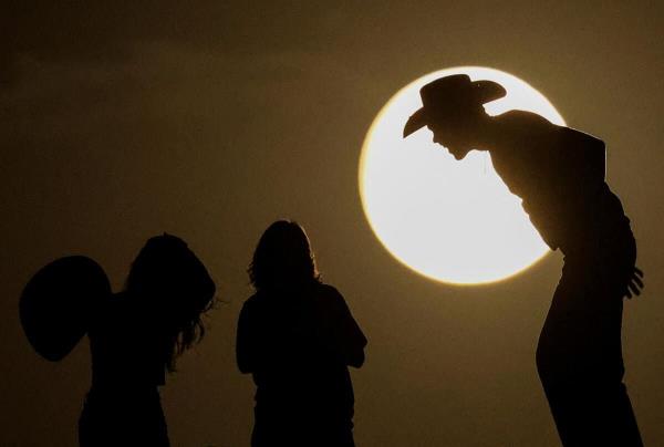 People watch the full moon on the day of the lunar eclipse at the Samalayuca Dunes on the outskirts of Ciudad Juarez, Mexico, September 17, 2024.