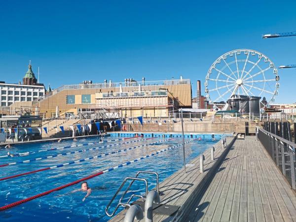 The Allas Sea Pool offers a view of a Ferris wheel and an office building designed by Alvar Aalto.