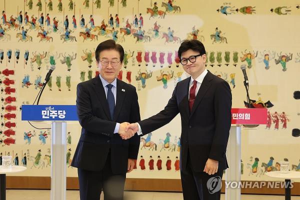 Han Dong-hoon (R), leader of the ruling People Power Party, and Lee Jae-myung, chief of the main opposition Democratic Party, shake hands ahead of their first official talks at the Natio<em></em>nal Assembly on Sept. 1, 2024. (Yonhap)