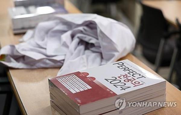 A doctor's gown and books for the natio<em></em>nal exam for the doctor's license are on a desk at a lecture room at a medical school in the southeastern city of Daegu on Sept. 6, 2024. (Yonhap)