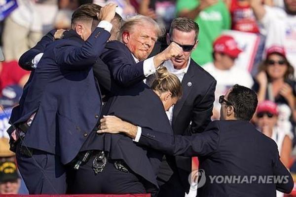 Former President Do<em></em>nald Trump is rushed off the stage at a campaign event in Butler, Pennsylvania, on July 13, 2024, after an assassination attempt, in this photo released by the Associated Press. (Yonhap)