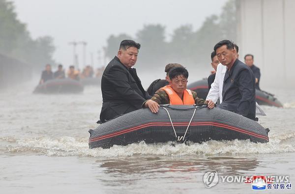 This photo, provided by North Korea's official Korean Central News Agency on July 31, 2024, shows the North's leader Kim Jong-un (L) inspecting flood-hit areas of Uiju County of North Phyo<em></em>ngan Province on a rescue boat. (For Use o<em></em>nly in the Republic of Korea. No Redistribution) (Yonhap)