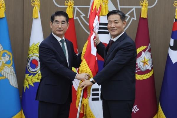 Former Defense Minister Shin Won-sik (R) hands the defense ministry's flag to new Defense Minister Kim Yong-hyun for Kim's inauguration ceremony as South Korea's new defense chief at the ministry's headquarters in central Seoul on Sept. 6, 2024, in this photo provided by the ministry. (PHOTO NOT FOR SALE) (Yonhap)