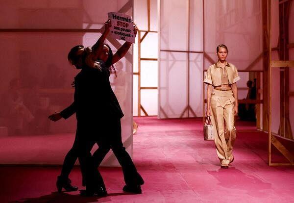 A protester holds a placard reading "Hermes stop exotic skin" as a model presents a creation by designer Vero<em></em>nique Nichanian as part of her Spring/Summer 2025 Women's ready-to-wear collection show for fashion house Hermes during Paris Fashion Week in Paris, France, September 28, 2024.