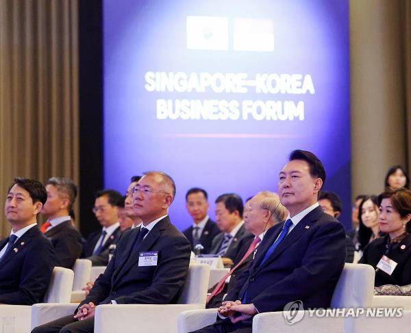 President Yoon Suk Yeol (R) and Hyundai Motor Group Executive Chair Euisun Chung (C) attend the Singapore-Korea Business Forum held at a hotel in Singapore on Oct. 8, 2024. (Yonhap)