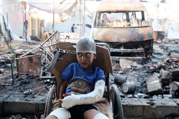 A Palestinian boy looks at the site of an Israeli strike on Al-Aqsa Martyrs Hospital wher<em></em>e tents sheltering displaced people went up in flames, in Deir al-Balah, Gaza on October 14, 2024.