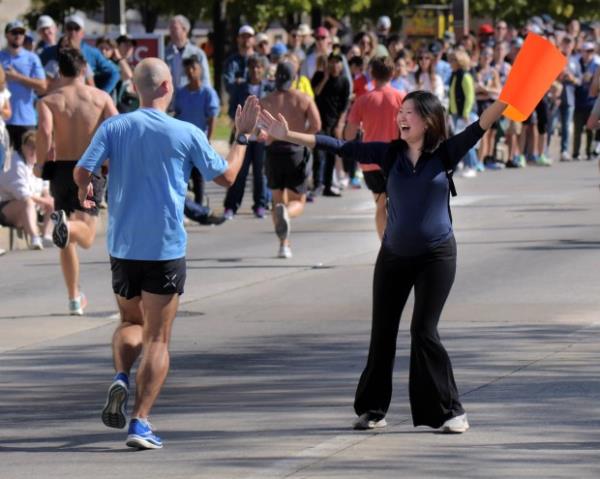 Spotting her husband, Christine Yu of Rockville celebrates with Mark Sailey who heads for the finish of the half marathon during the 24th Annual Running Festival at the inner harbor. (Karl Merton Ferron/Staff)