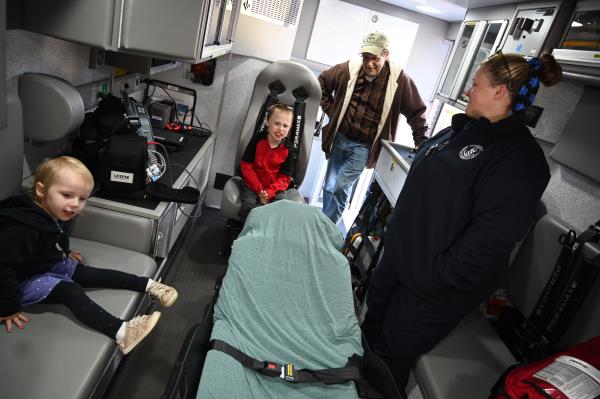 Danielle Ward, paramedic with Harford County Department of Emergency Services talks with Fawn Grove resident Mike Fenske and his grandchildren Grace, 3, and Luke, 8, a<em></em>bout the equipment inside an ambulance during an open house at Whiteford Volunteer Fire Company on Saturday. (Brian Krista/staff photo)