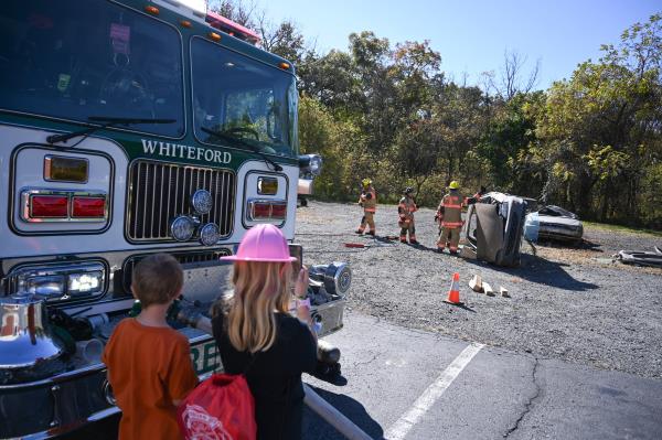 Children watch as firefighters work to remove the roof of a car during a vehicle extrication demo<em></em>nstration during an open house at Whiteford Volunteer Fire Company on Saturday. (Brian Krista/staff photo)