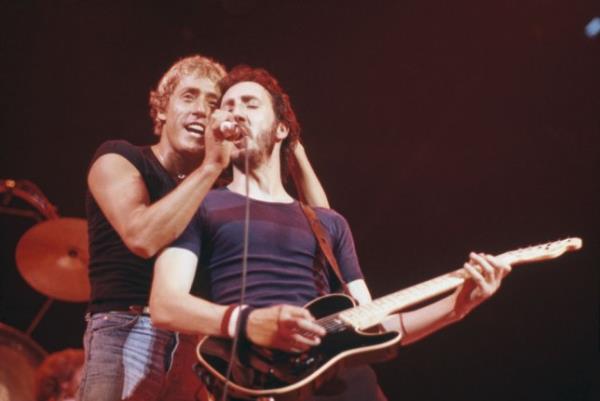 Roger Daltrey (left) holds a microphone for Pete Townshend of The Who as theyperform on stage during a tour of the United States in September 1979. 