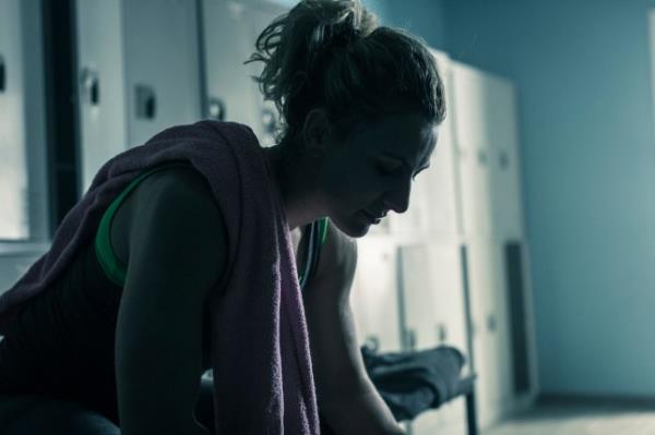 Women sitting on bench in locker room after workout