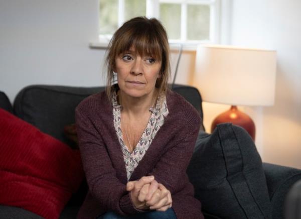 Rhona sat on the sofa at Gus's home in Emmerdale