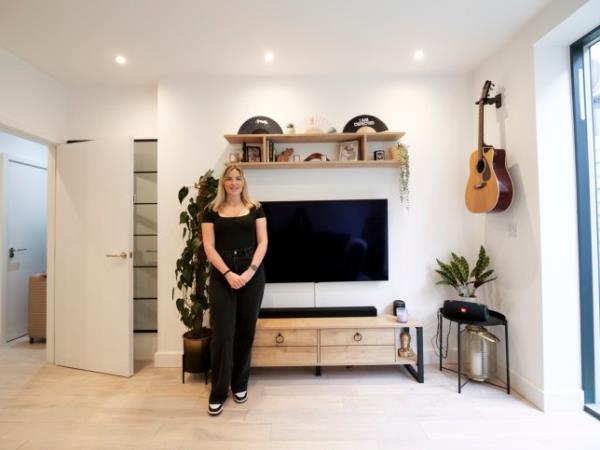 Lauren May is pictured in her small and very neat one bedroom apartment in west London, wearing a black top, black trousers and black and white trainers