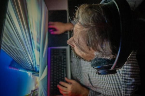 Middle-aged man playing video games at home