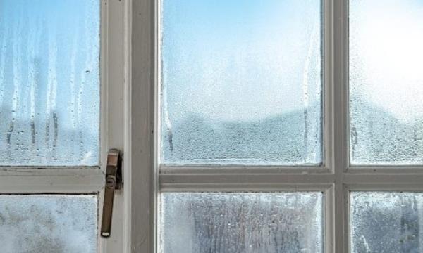 Cold room interior looking out o<em></em>nto water co<em></em>ndensation formed on interior windows during early winter.