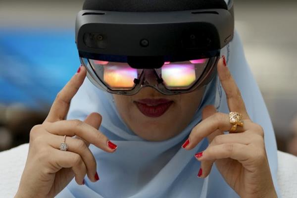 A woman in a hijab wearing a pair of virtual reality goggles