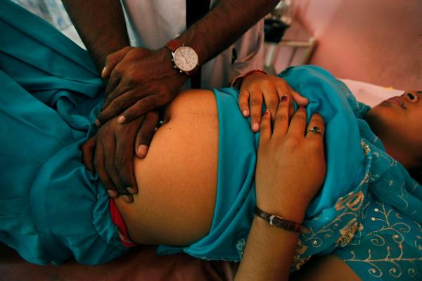 A doctor in Nepal examines a pregnant woman in Nepal.