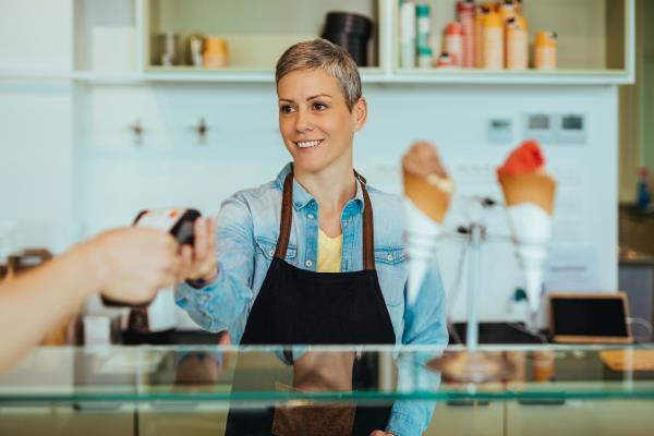 Woman standing behind a counter serving icecream