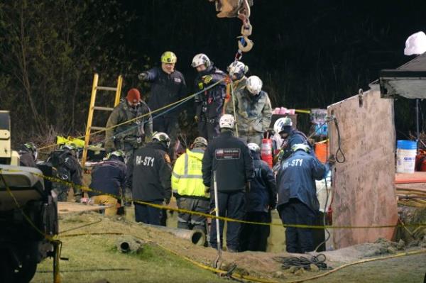 Rescue workers search through the night in a sinkhole for Elizabeth Pollard, who disappeared while looking for her cat, in Marguerite, Pa., Tuesday, Dec. 3, 2024. (AP Photo/Gene J. Puskar)