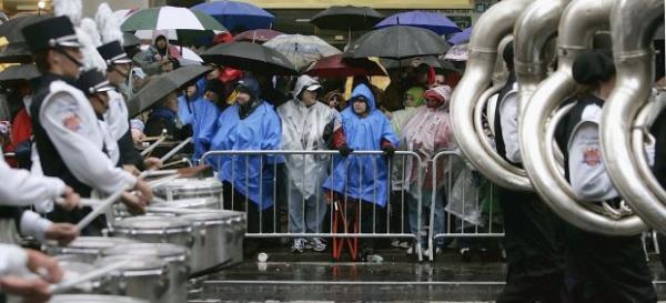 People wearing po<em></em>nchos and holding umbrellas protect themselves from the rain and wind as they watch the 80th Macy's Thanksgiving Day parade, November 23, 2006 in New York City. (Photo by Stephen Chernin/Getty Images)