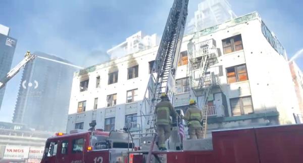 firefighters with ladder over morrison hotel 