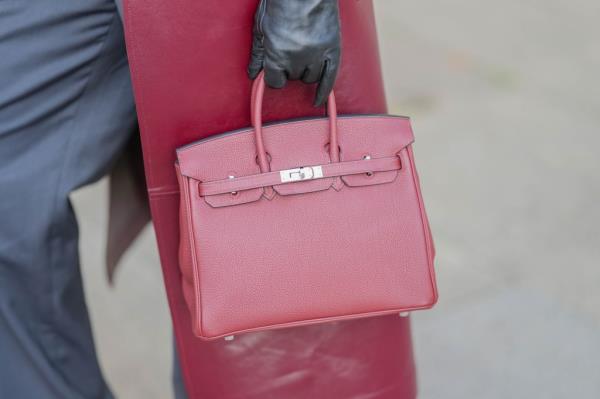 Virginie Co<em></em>nte during a street style fashion photo session in Paris, holding a burgundy leather Hermes Birkin bag and wearing black leather Zara gloves on November 11, 2024