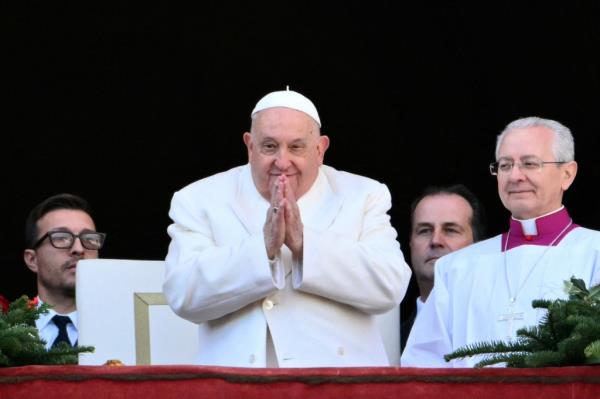 Pope Francis looks on from the main balcony of St. Peter's basilica after the Urbi et Orbi message and blessing to the city and the world as part of Christmas celebrations, at St Peter's square in the Vatican on December 25, 2024.