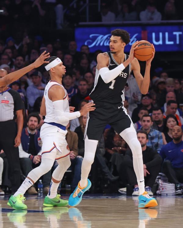 Spurs center Victor Wembanyama #1 looks for an opening as New York Knicks guard Josh Hart #3 defends