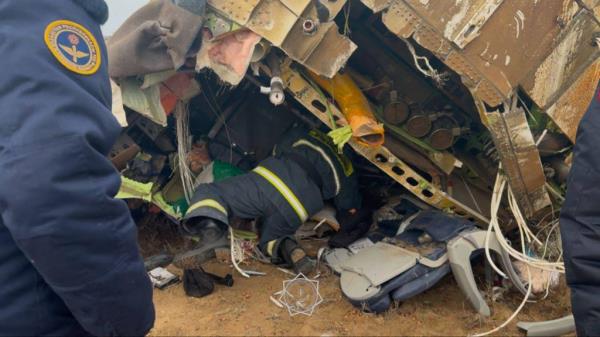 emergency specialists work at the crash site of an Azerbaijan Airlines passenger jet near the western Kazakh city of Aktau on December 25, 2024. 