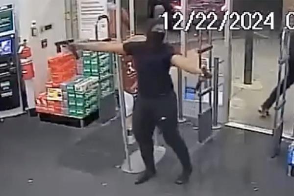 A person in a black mask robbing a Walgreens store at night