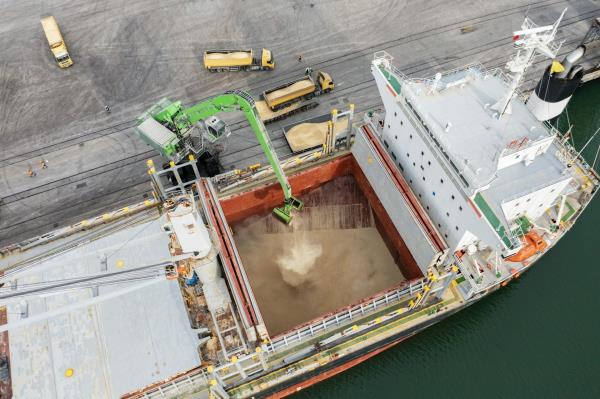 A machine loading grain into a cargo ship.