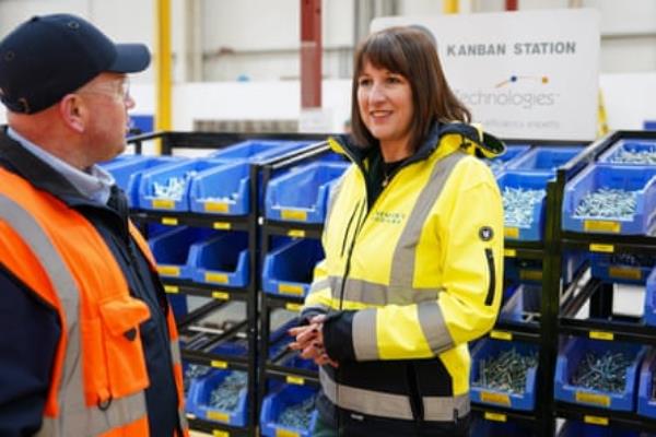 Rachel Reeves in a hi-vis jacket talking to a man in a factory